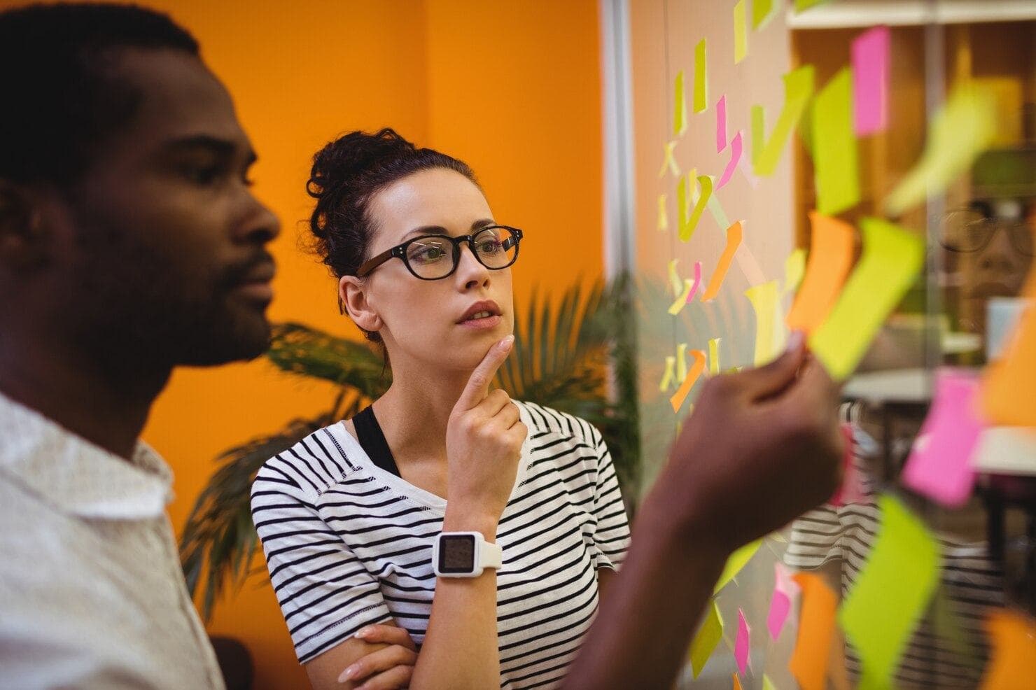 Marketing planner reviewing ideas on a wall of notes